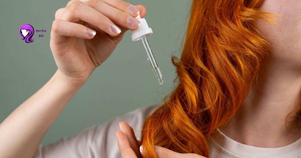 Close-up of hands applying argan oil to hair end for moisture