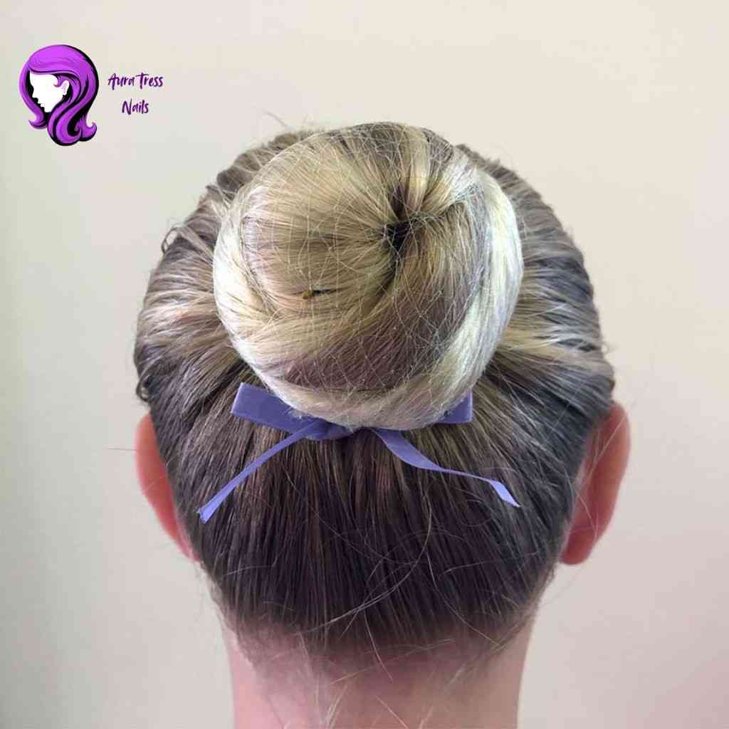 Woman with a clean, tight ballerina bun, achieving a polished and sophisticated look