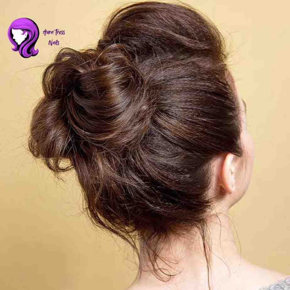 Woman with a high, loosely styled messy bun, offering a relaxed yet elegant night-out style