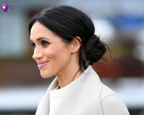 A sophisticated low chignon hairstyle inspired by Meghan Markle, featuring a sleek, neatly pinned bun at the nape of the neck.