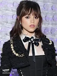 Young woman with soft curtain bangs framing her face, reminiscent of Jenna Ortega's trending hairstyle.