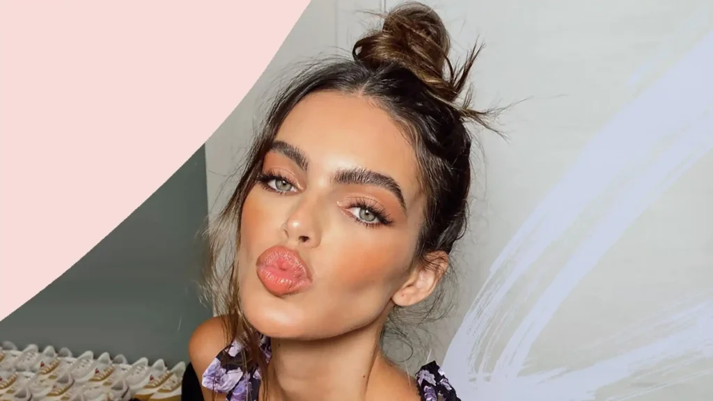 Close-up of a woman styling her hair into a relaxed messy bun similar to Zendaya's red carpet look.